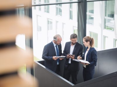Group of businesspeople having a discussion near staircase in office